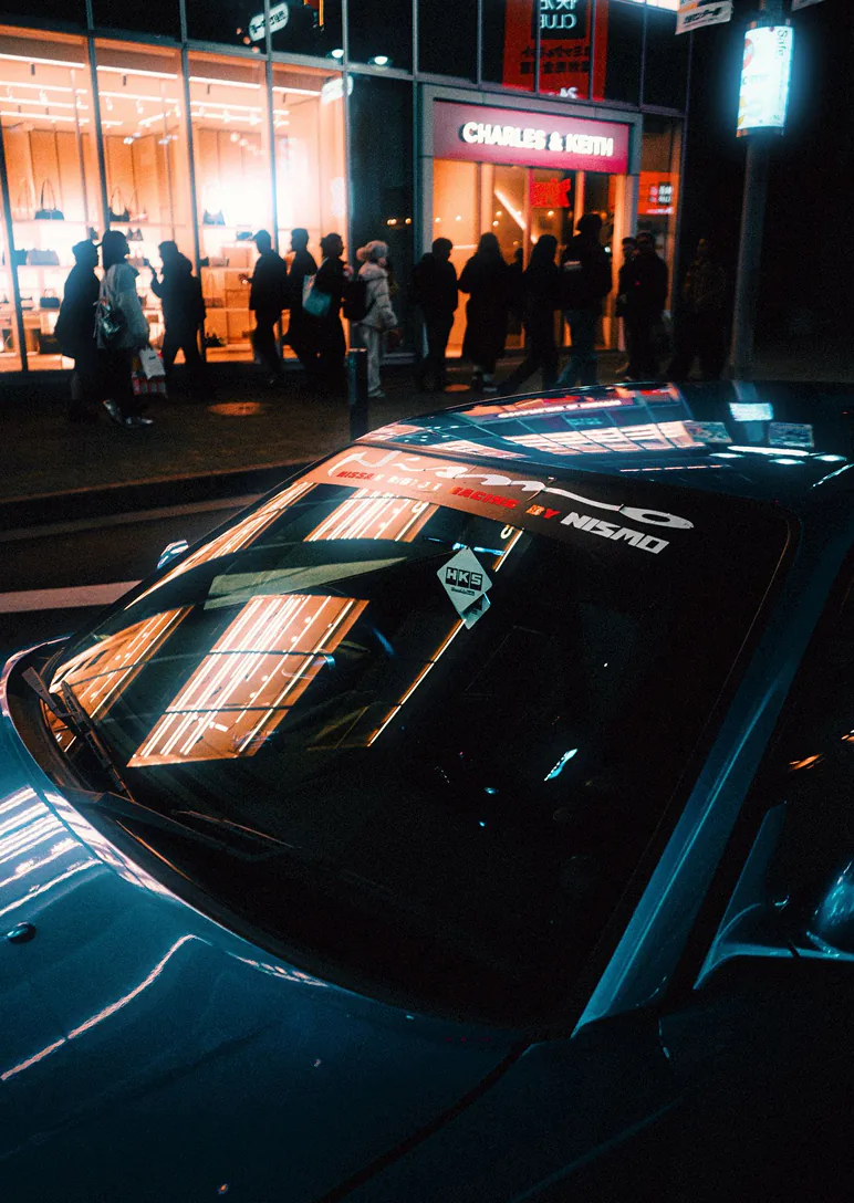 JDM sports car parked under Tokyo city lights